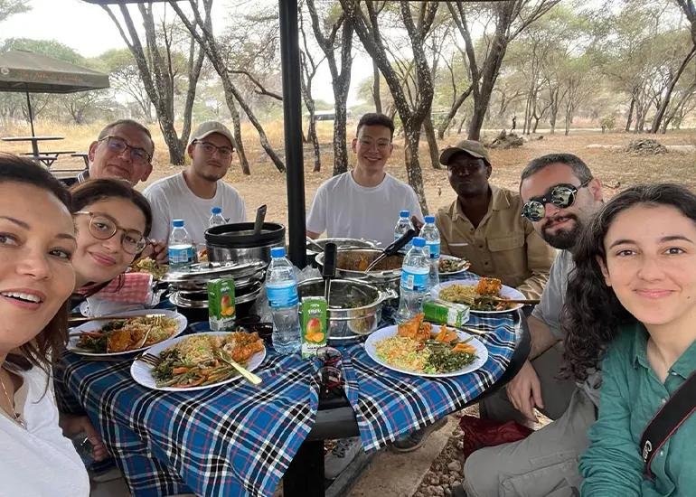 Midday Bush Lunch Mikumi National Park - LITTLE LION TOURS AND SAFARIS Safari Guests Enjoying a Bush Lunch in Mikumi National Park Tanzania